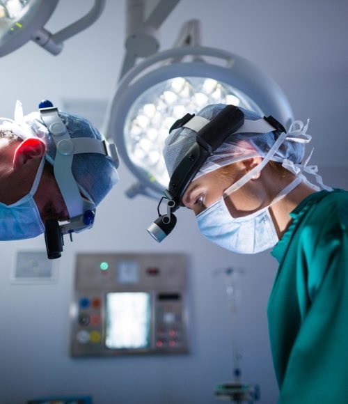 Surgeons wearing surgical loupes while performing operation in operation theater